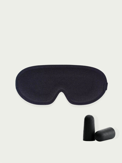 Black sleep mask  and black ear plugs on a light beige background 